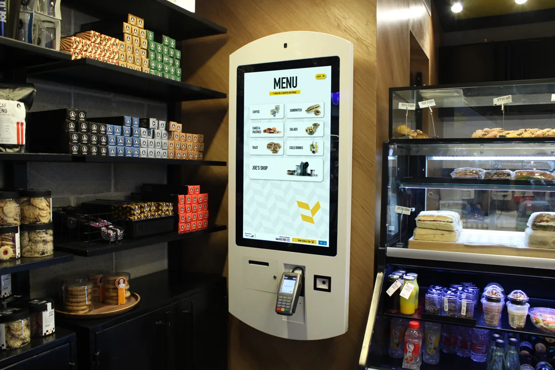 Tapit kiosk alongside a café food display and drinks refrigerator